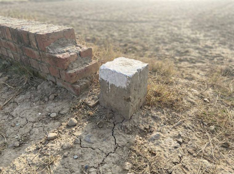 Sample photo of a concrete corner marker at the edge of the plot