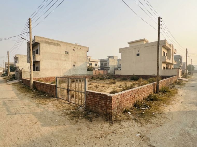 Sample photo of the full frontage of a vacant walled plot seen from the road